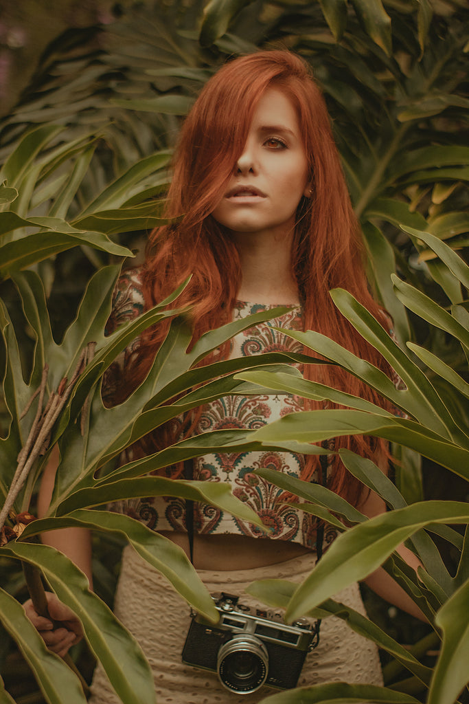 red haired woman surrounded by nature