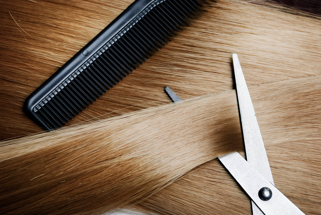 blond hair being combed and cut with scissors