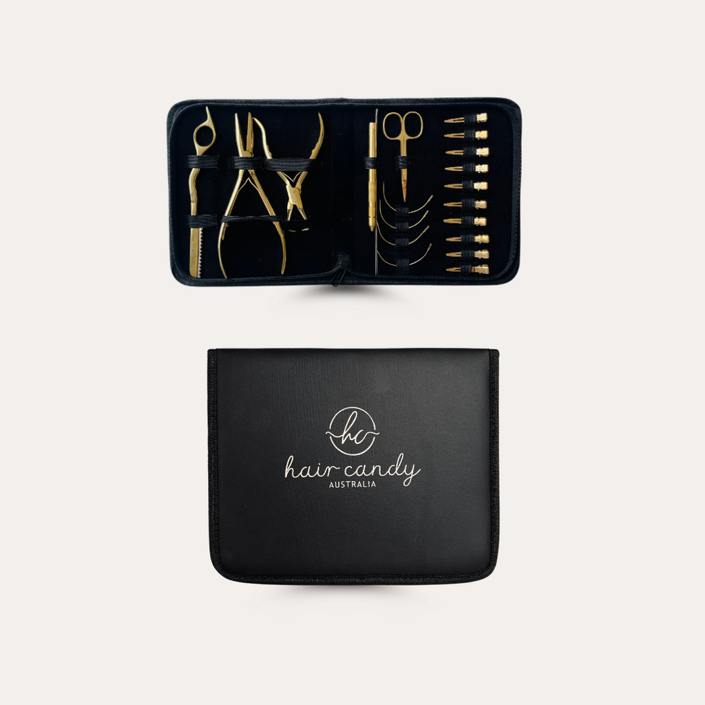 A deluxe hair extension tool kit with a black vinyl case, displaying various gold-colored tools neatly organized inside.