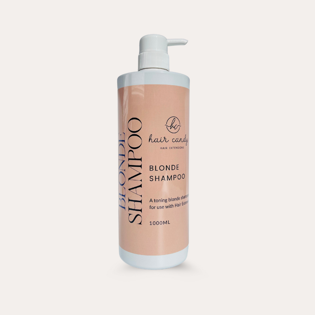 A 1L bottle of Hair Candy Blonde Shampoo with a pump dispenser, predominantly pink in color with white and grey text.