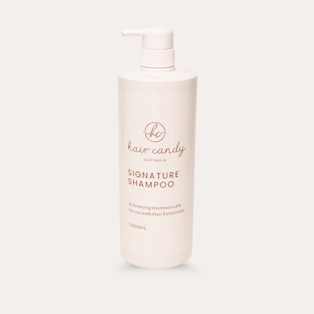 White shampoo bottle with 'the hair candy' branding on a light gray background