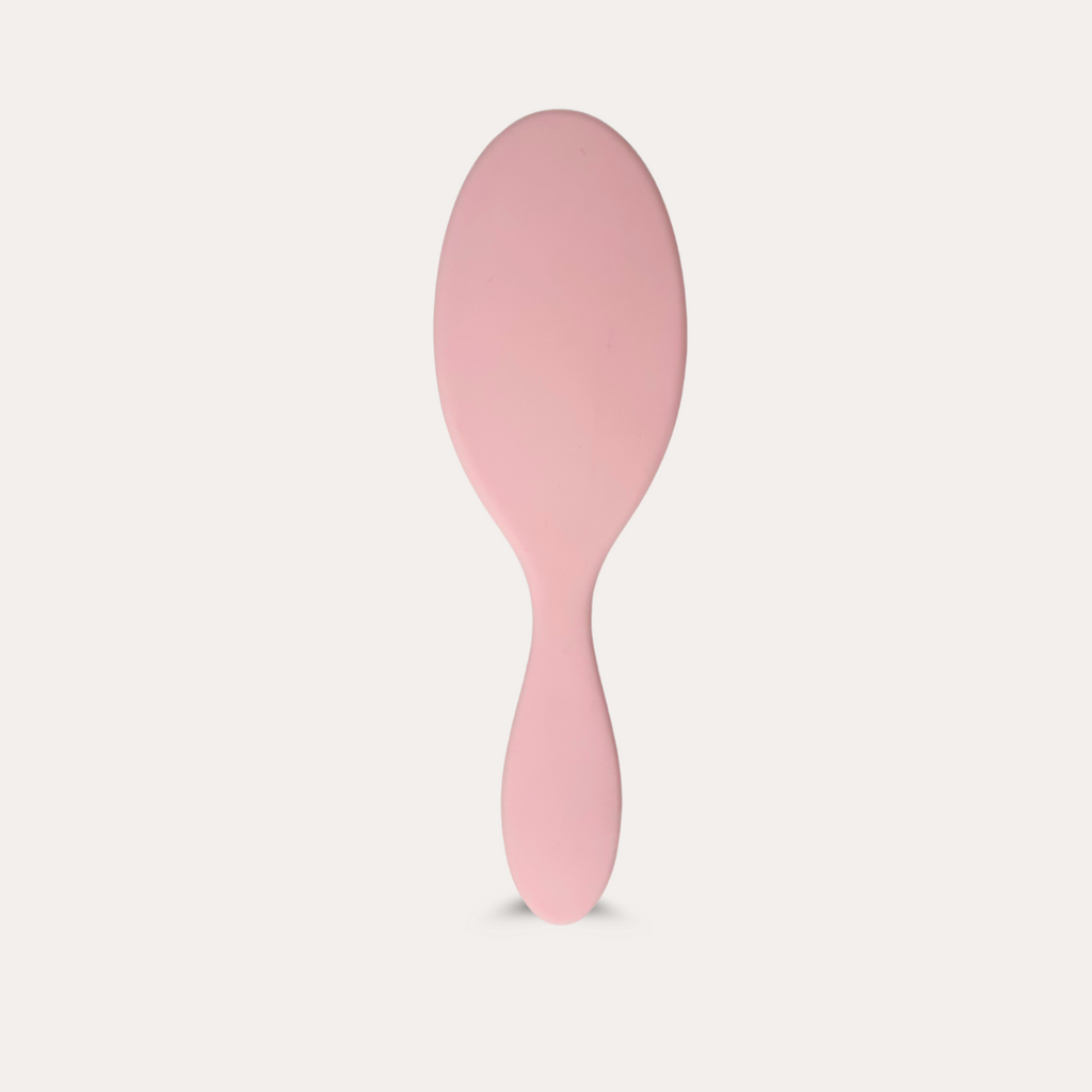 Pink hairbrush on a light gray background