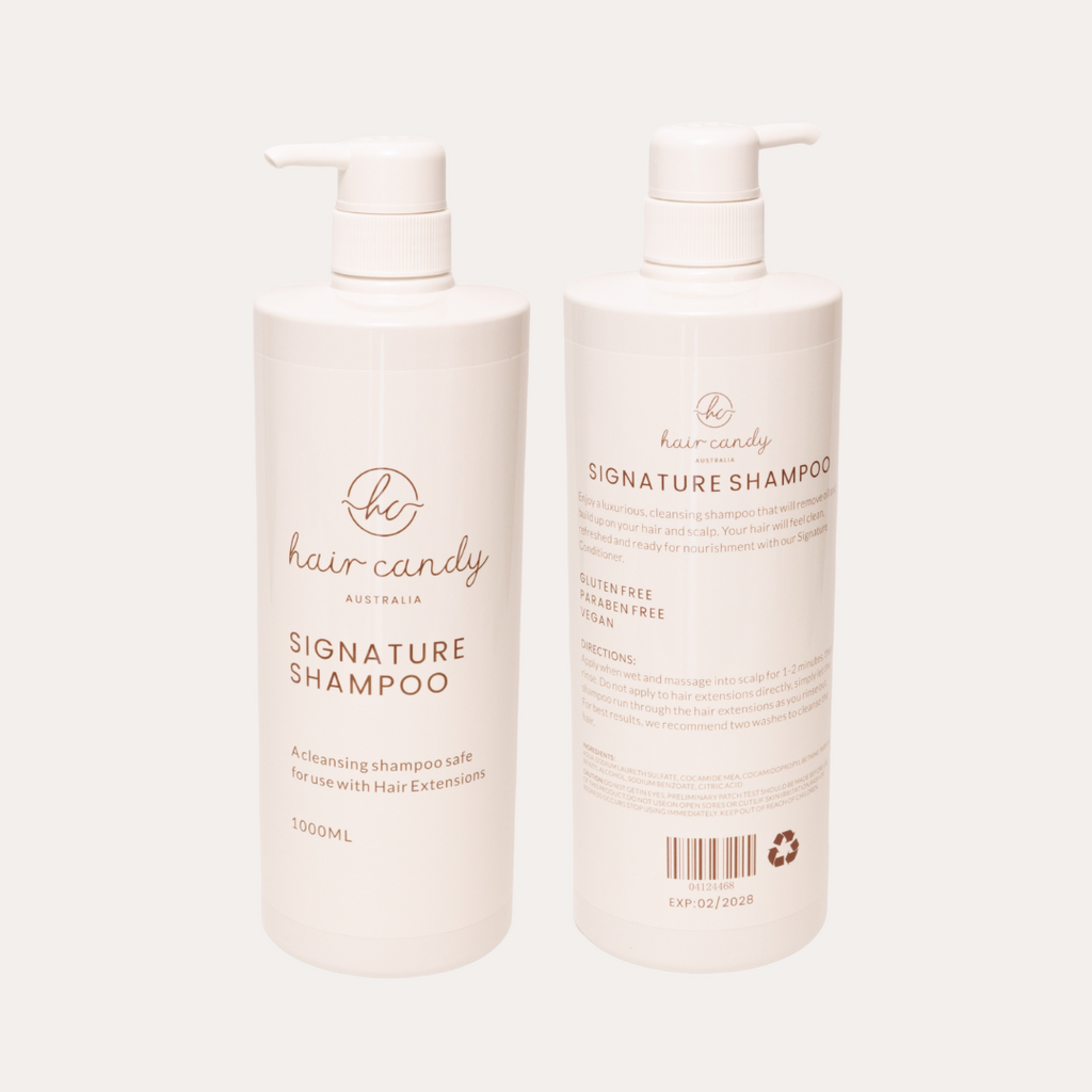 Two bottles of 'be hair candy' signature shampoo on a white background
