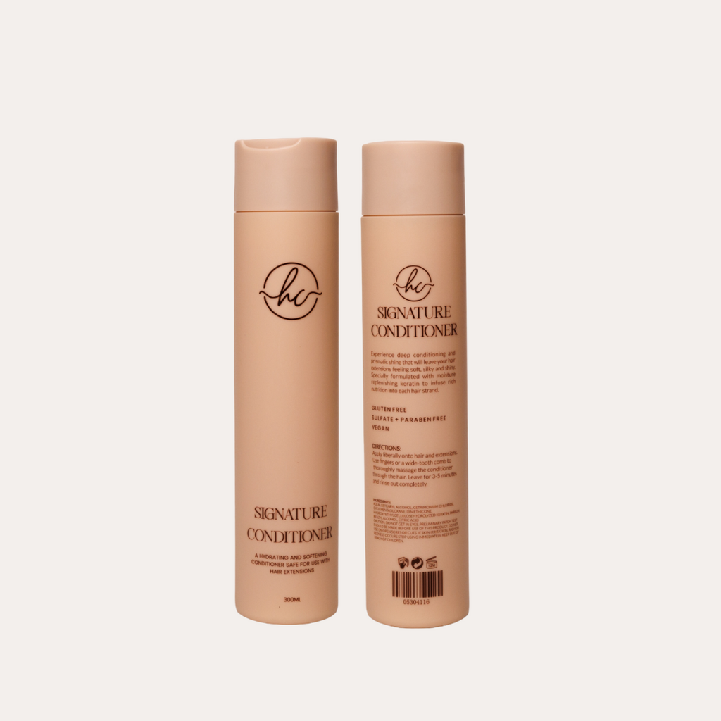 Two bottles of 'Signature Conditioner' on a light beige background