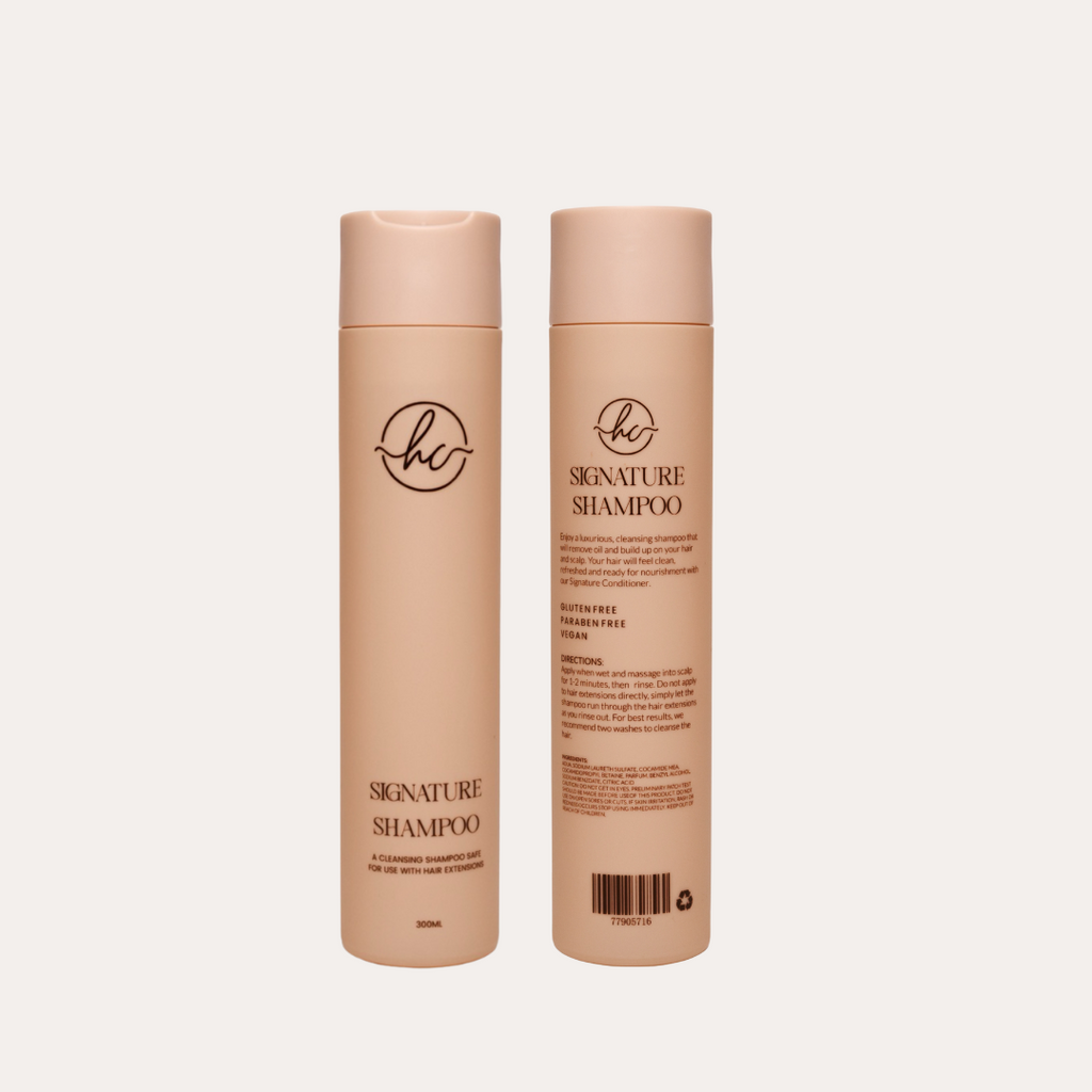 Two bottles of 'Signature Shampoo' on a light beige background