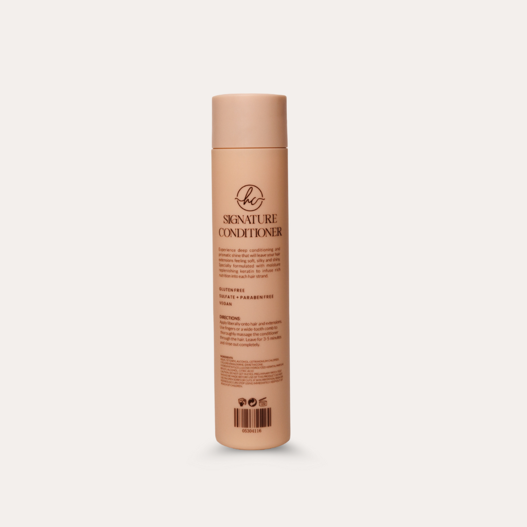 Beige bottle of 'Signature Conditioner' on a light beige background