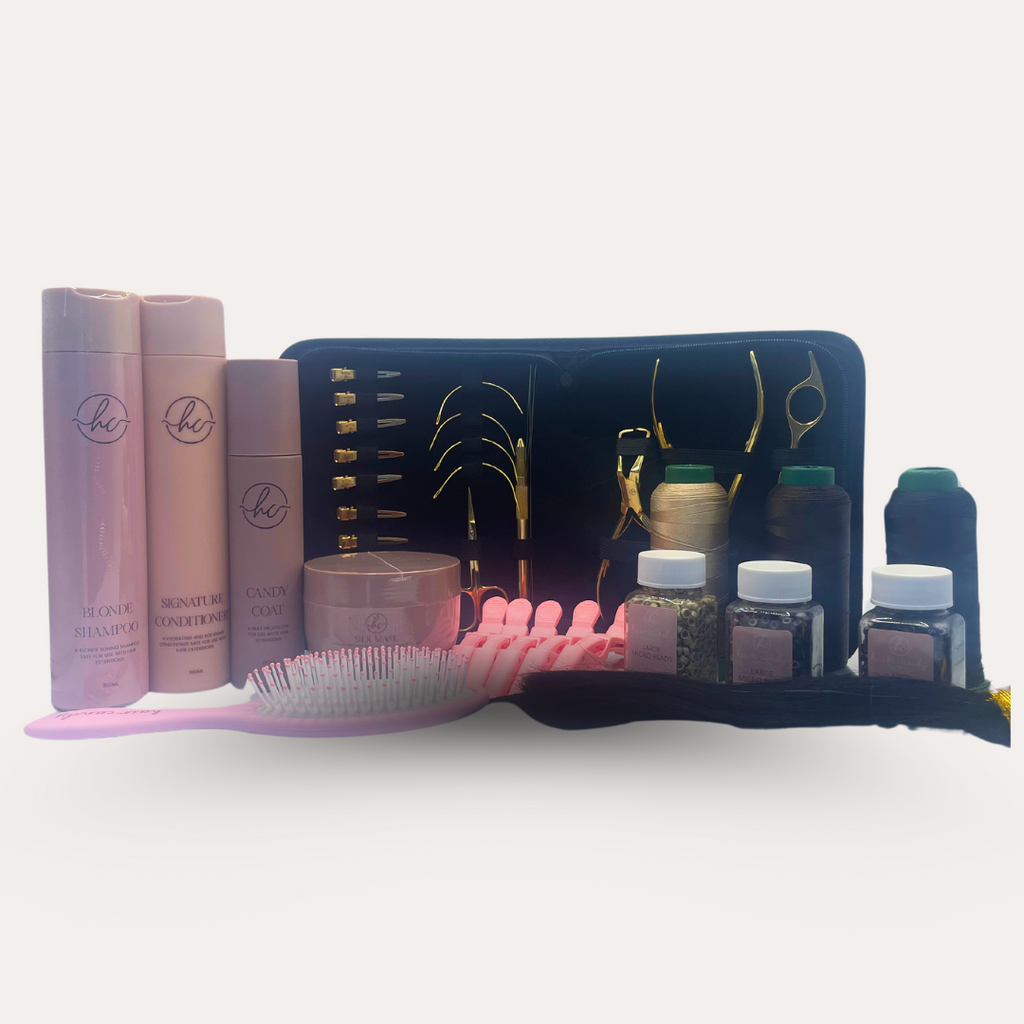 An array of hair extension tools and accessories displayed, including scissors, razors, pliers, threaders, needles, flat clips, micro beads, thread spools, hair grips, an alligator clip, and a practice hair weft.